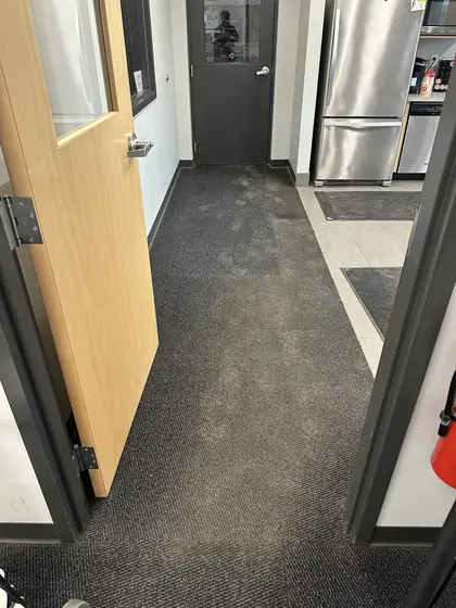 Office break room corridor carpet tile with heavy traffic soil before cleaning