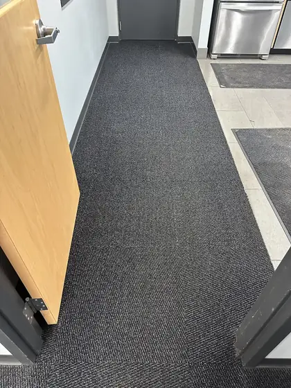 The same corridor carpet tile restored to an even tone after cleaning