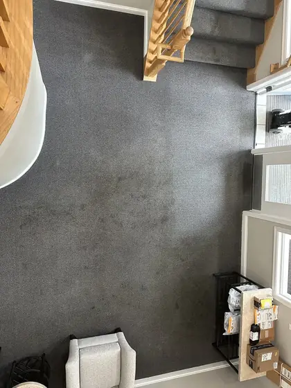 Open room off a stairwell landing with visibly soiled carpet before cleaning